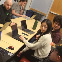 people at a table program the Arduino boards in their USB rubber duckies